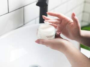 person holding white and black plastic bottle